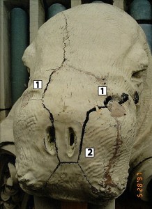 Figure 5: Existing conditions in late 1995. Note the dark spots above the nostrils to the right and left (1). These are the holes grout was filled through. Note that they are on top of the walrus head. Also note the cracking of the snout (2). Credit: Wiss, Janney, Elstner Associates, Inc.